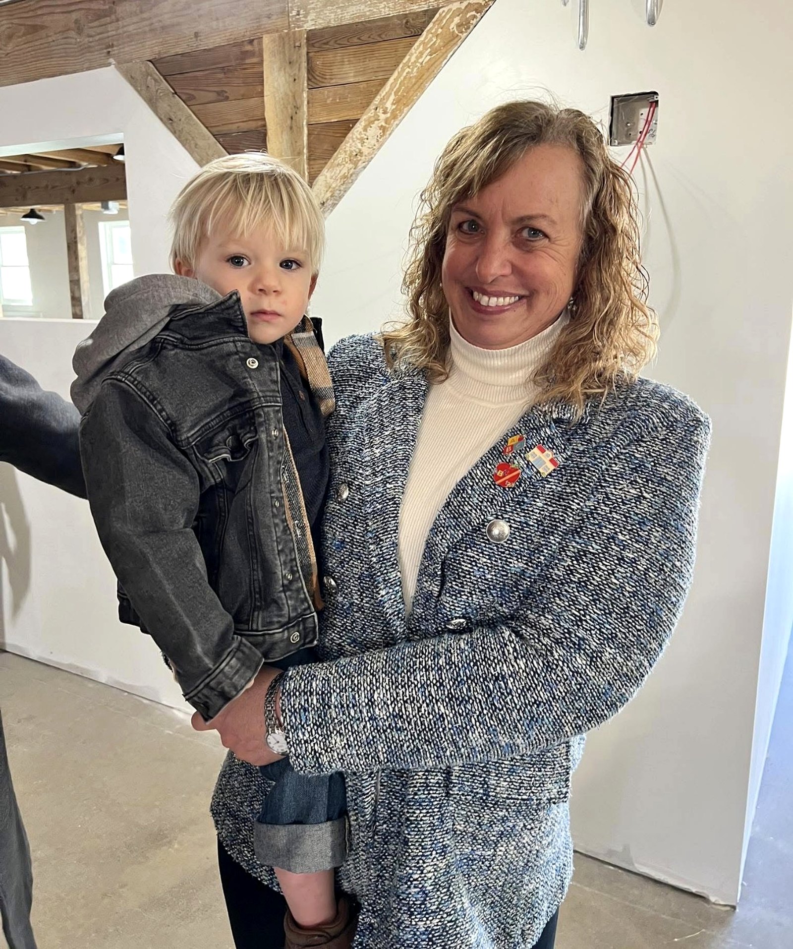 Founder Gina Hensley holding her grandson Theo inside the restored school.