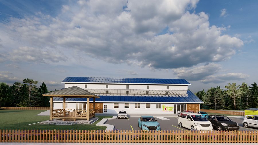 Architectural rendering of The Giving Tree Montessori School: a long barn-form building with clapboard siding, a standing-seam roof, clerestory vents and sliding barn doors, a wide view with the timber pavilion and parking to one side.